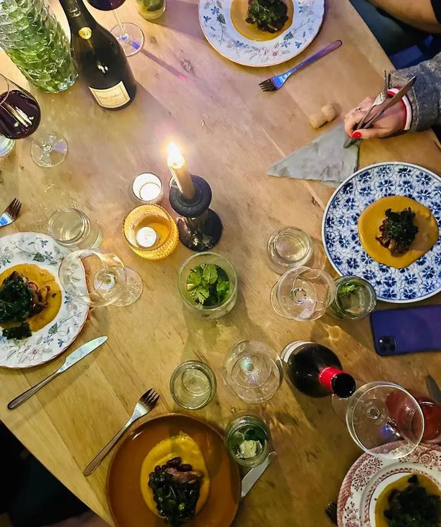 Een tafel vol gerechten, kaarsen, glazen wijn en water